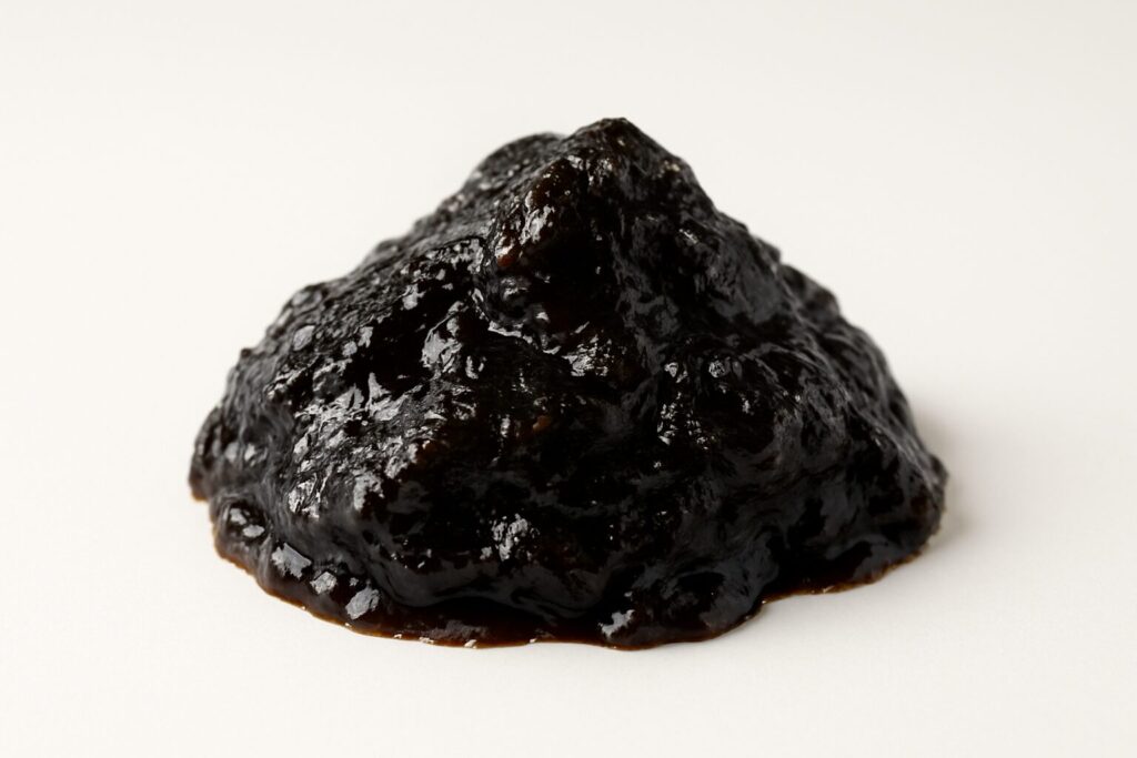 Close-up view of shilajit resin on a white background